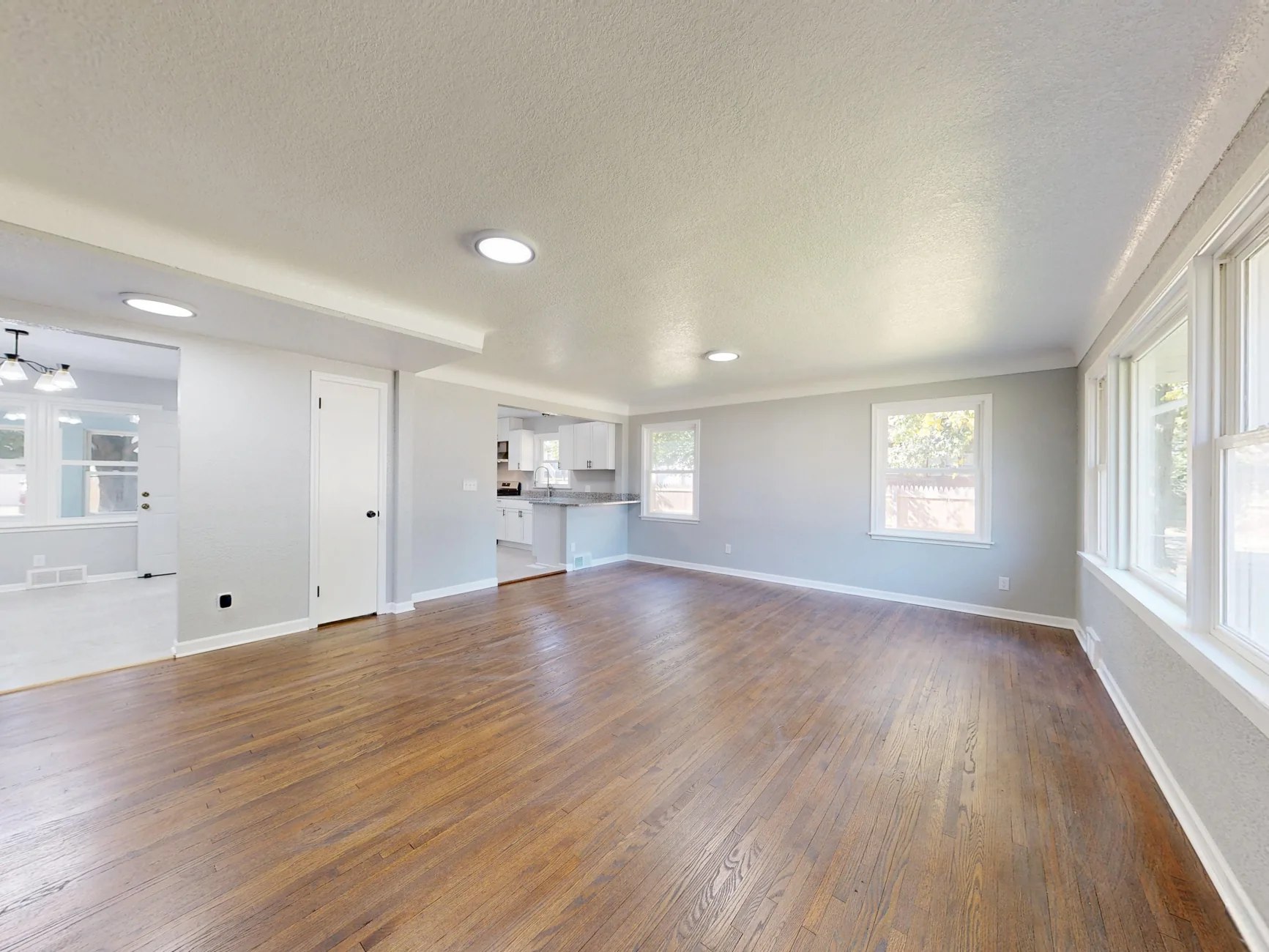 Renovated airy room featuring wood flooring